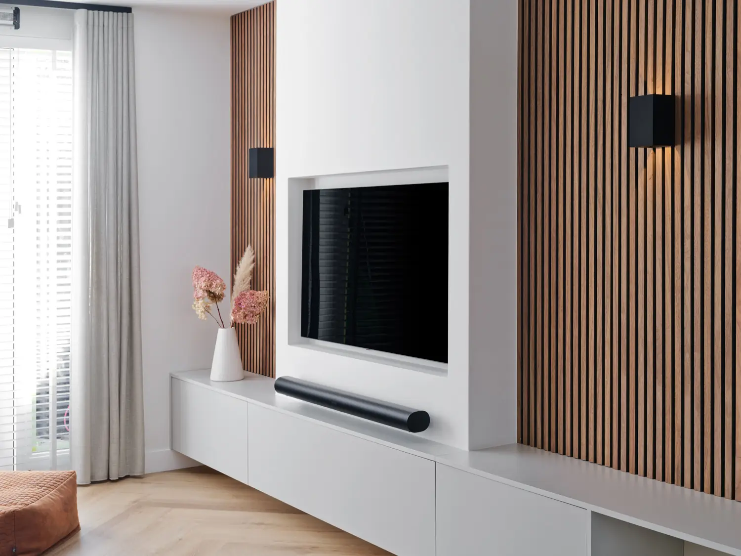 TV-wand met houten lattenafwerking Moderne tv-wand met houten latten, strak meubel en minimalistisch design.